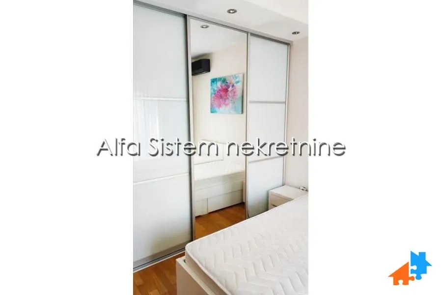 Bedroom with a large built-in mirrored wardrobe and a bed.