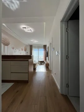 Pogled iz hodnika na svijetli dnevni boravak sa modernim namještajem i drvenim podom. - image 6