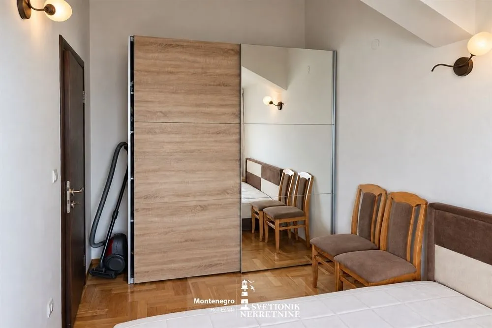 Namještena spavaća soba sa velikim garderoberom i bračnim krevetom.