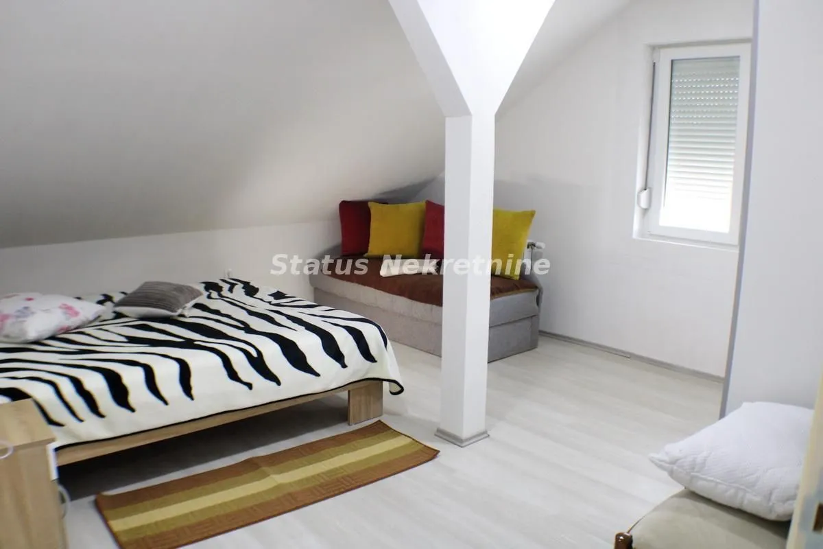 Attic bedroom with a bed and a window.
