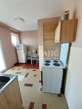 Small kitchen with a stove and refrigerator combined with a dining area. - image 5
