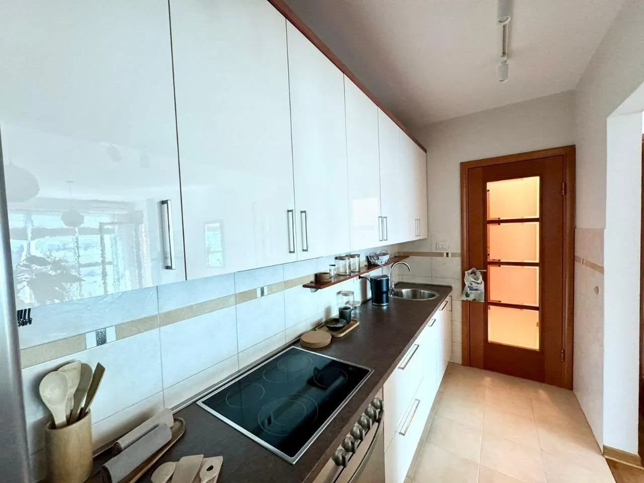 Small kitchen with white cabinets, dark countertops, and a built-in cooktop.