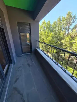 Prostrani natkriveni balkon sa tamnim podnim pločicama i pogledom na zelenilo. - image 13