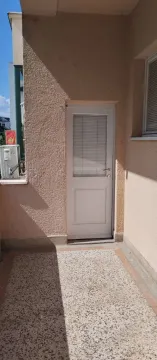 Dio terase sa bijelim ulaznim vratima i popločanim podom. - image 4