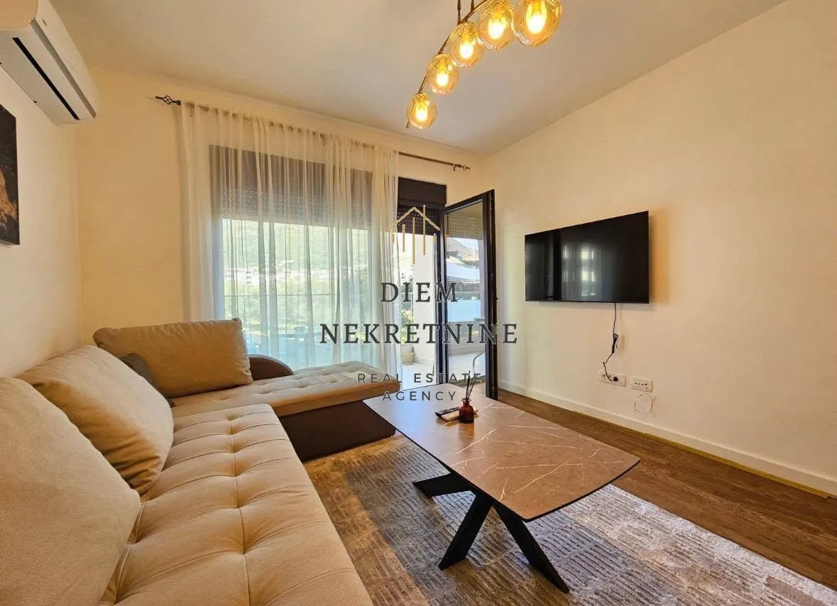 Living room with sofa, coffee table and balcony access.