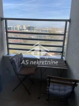 Manji namešteni balkon sa stolom i stolicama i pogledom na grad. - image 11