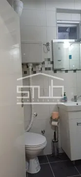 Smaller bathroom with a shower cabin, washbasin, and toilet. - image 13