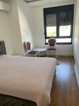 Nameštena spavaća soba sa bračnim krevetom, stočićem i dve stolice pored prozora. - image 10