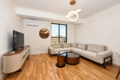 Spacious living room with a sectional sofa, TV unit, and wooden flooring. - image 2