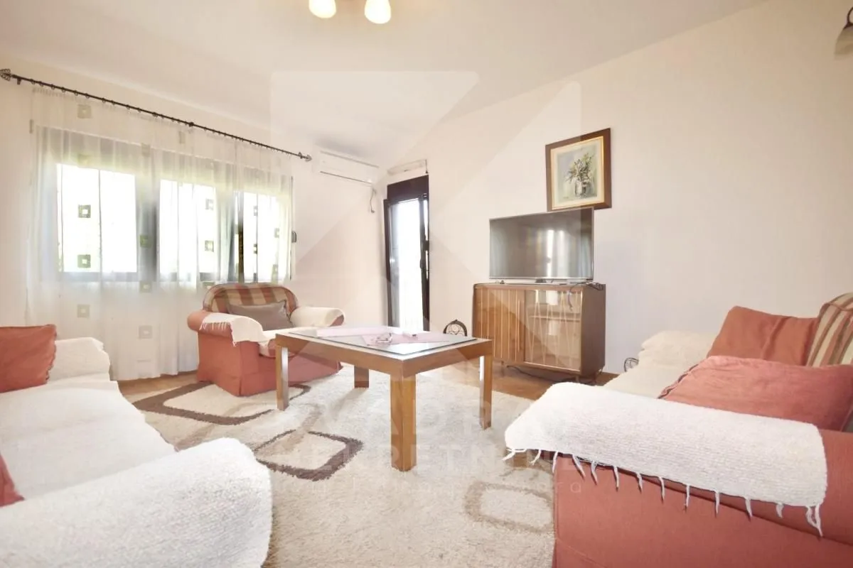 Living room furnished with a seating set, coffee table, and television.