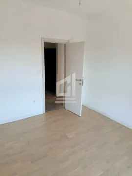 Prazna soba sa bijelim zidovima i drvenim podom. - image 3