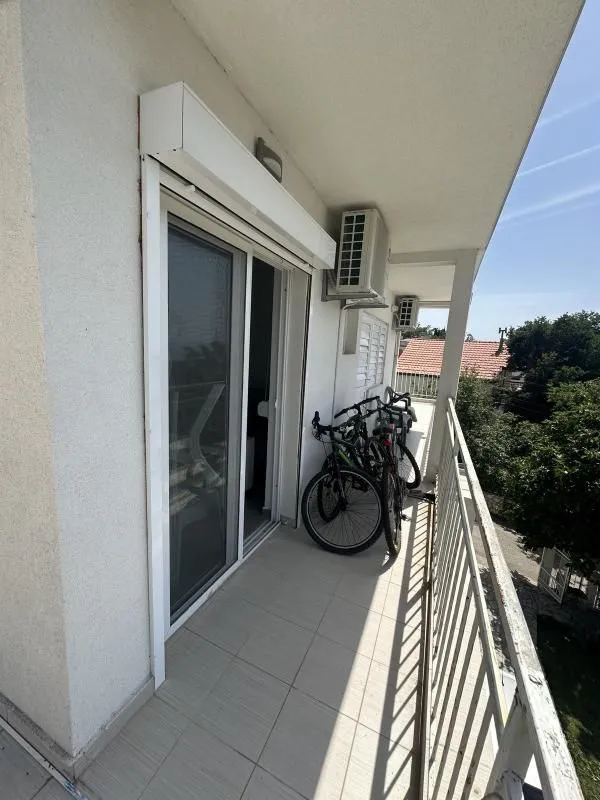 Dugi balkon sa kliznim vratima i parkiranim biciklima.