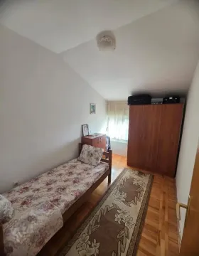 Manja spavaća soba sa krevetom, drvenim ormarom i tepihom. - image 10