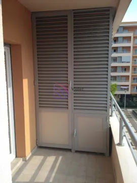 Covered balcony with a closed storage area and a view of surrounding buildings. - image 7