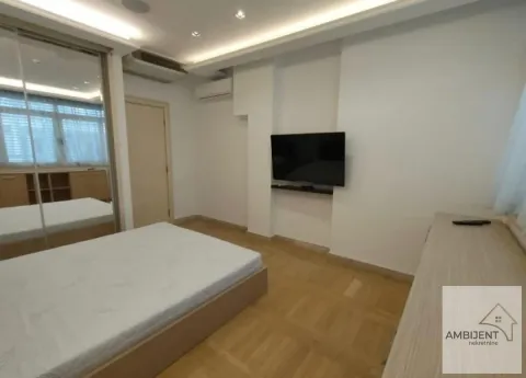 Furnished bedroom with a double bed, fitted wardrobe, and wall-mounted TV. - image 11