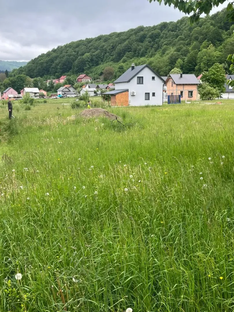 Pogled na kuću i okolno zelenilo sa travnjakom.