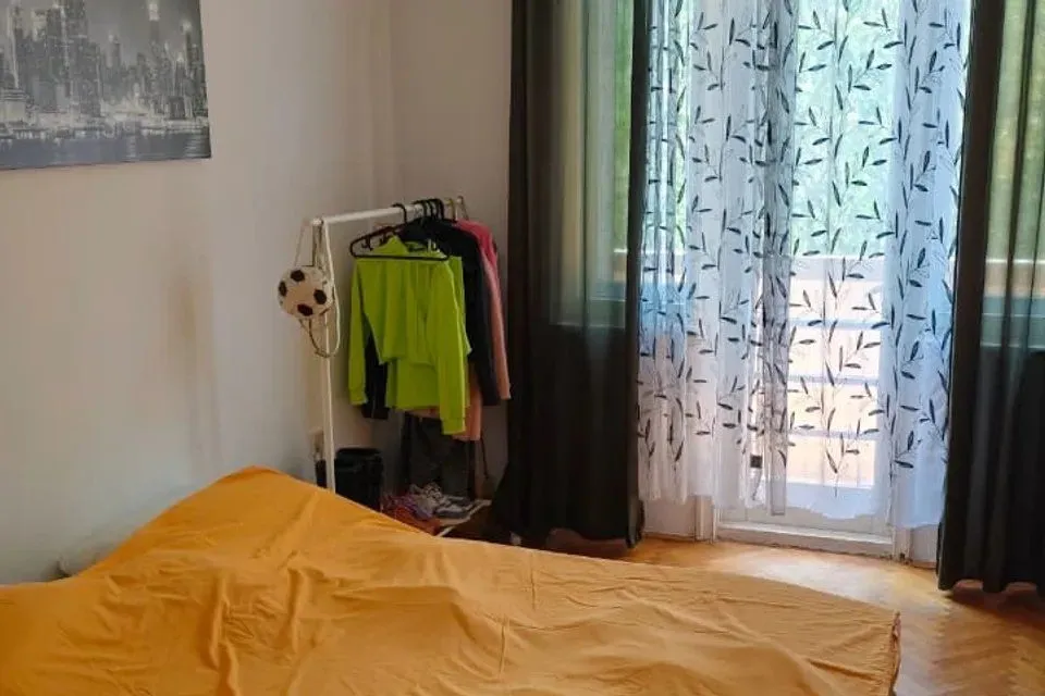 Spavaća soba sa bračnim krevetom, garderoberom i izlazom na terasu.