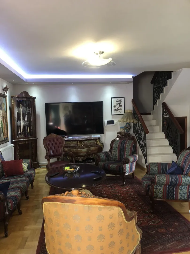 Living room with classic furniture and indoor stairs.
