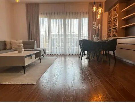 Living room with sofa, dining area, and wooden flooring. - image 8