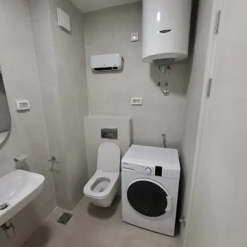 Modern bathroom equipped with sanitary ware, water heater and washing machine. - image 12