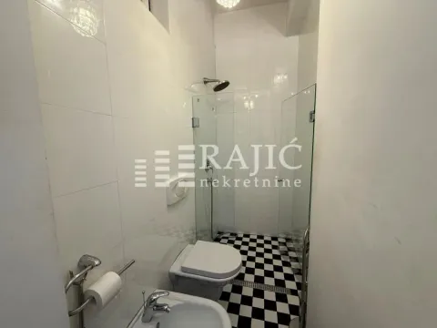 Small bathroom with a shower cabin and black and white floor tiles. - image 9