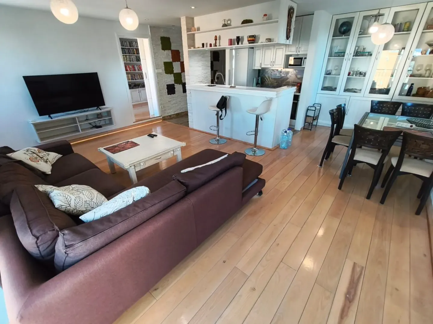 Living room with sofa, dining area, and kitchen counter.