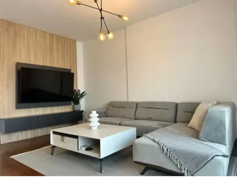 Modern living room with a sectional sofa, coffee table, and TV unit. - image 3