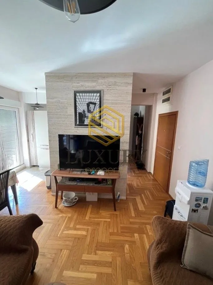 Dnevna soba sa parketom i televizorom.