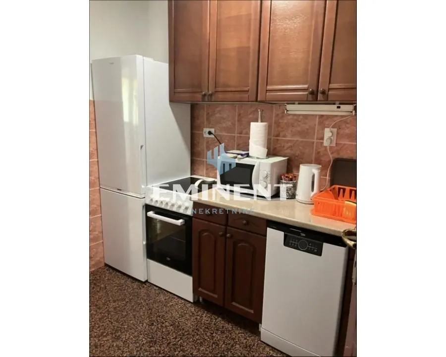 Smaller kitchen with wooden cabinets and white goods.