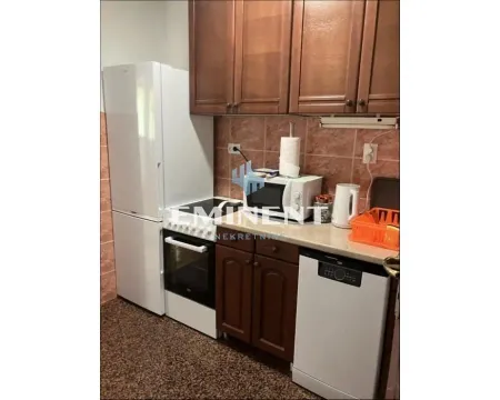 Smaller kitchen with wooden cabinets and white goods. - image 4