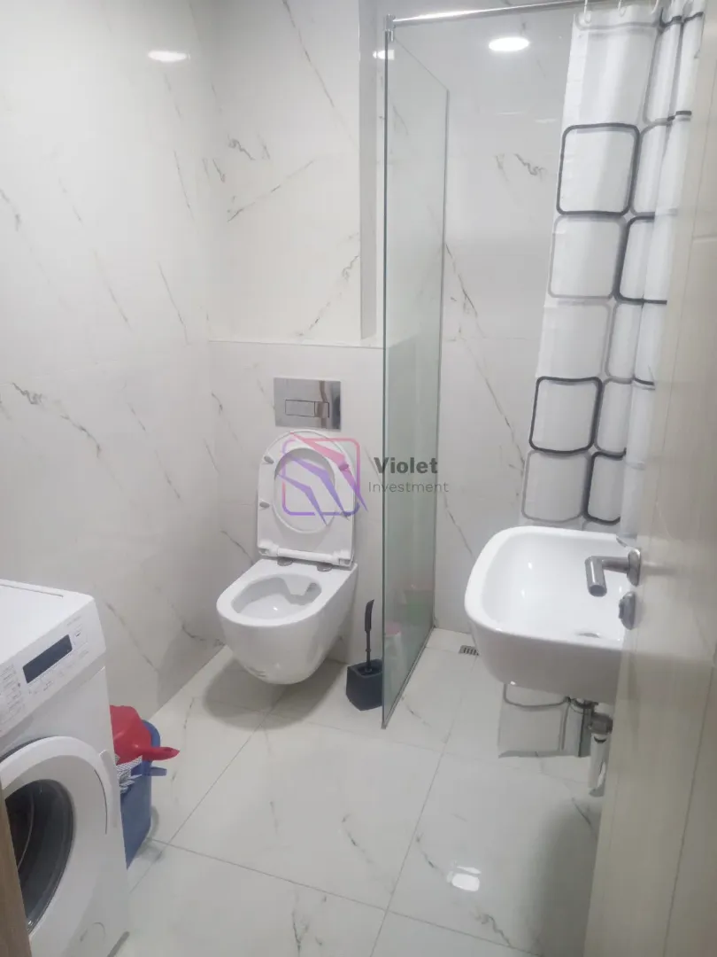 Kupatilo opremljeno sanitarijama, tuš kabinom i veš mašinom.
