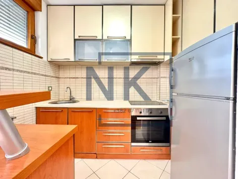 Kitchen with wooden cabinets, built-in appliances, and a refrigerator. - image 4