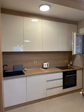 Modern kitchen with white cabinets and a wood-grain countertop. - image 5