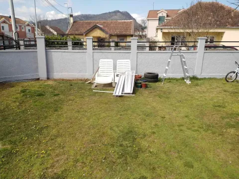 A house yard with a lawn and a concrete fence. - image 14