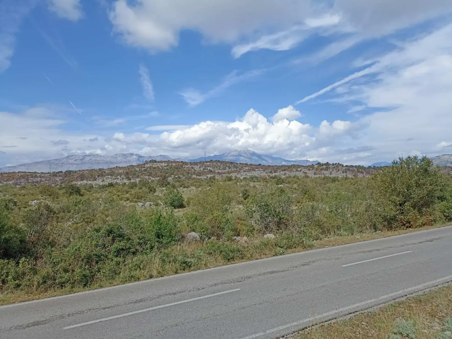 Pogled na prirodni pejzaž i okolno zemljište pored puta.