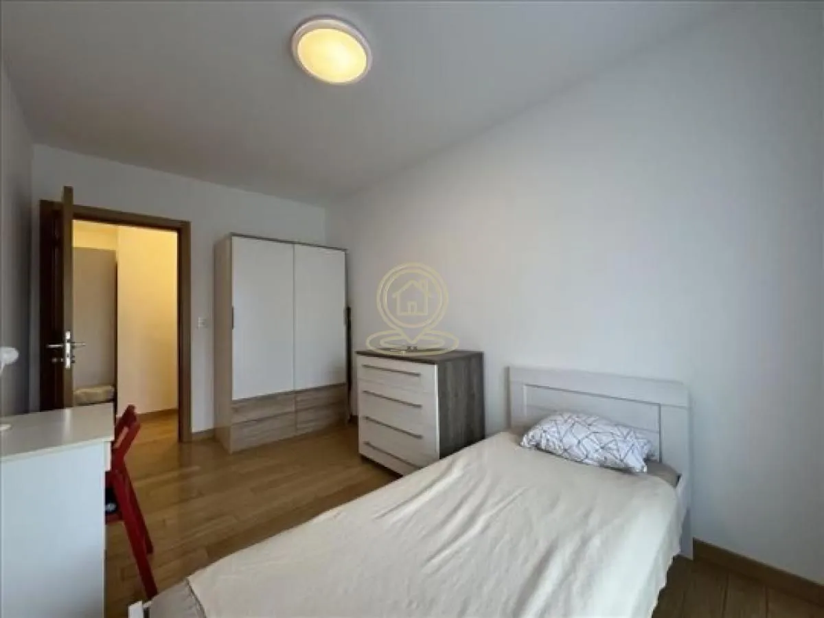 Small bedroom with a bed, wardrobe, and desk.