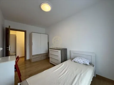 Small bedroom with a bed, wardrobe, and desk. - image 5