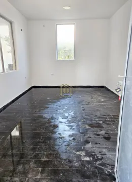 Empty room with white walls and dark floor tiles. - image 4