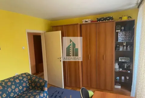 Spavaća soba sa drvenim ormarima, krevetom i žutim zidovima. - image 6