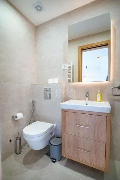 Moderno opremljeno kupatilo sa umivaonikom i ugradnom wc šoljom.
