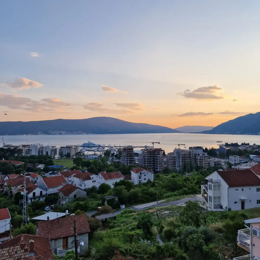 Pogled sa nekretnine na grad, marinu i zaliv u sumrak.