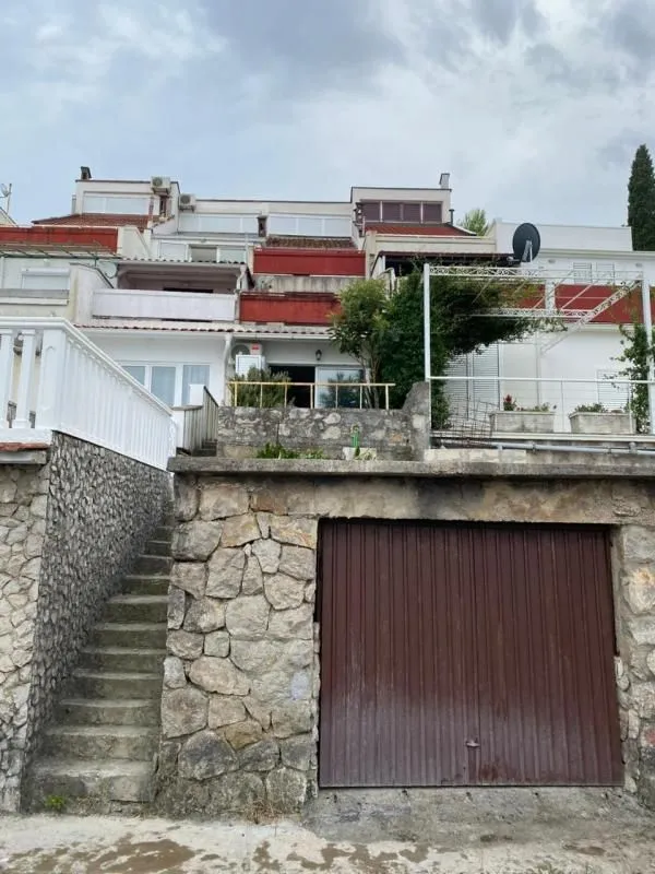 Spoljašnji izgled kuće sa garažom i stepeništem.