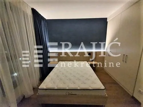 Modern bedroom with a double bed, built-in wardrobe, and lighting.