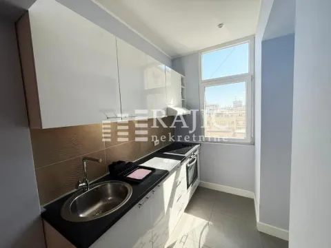 Small bright kitchen with white cabinets and a sink next to the window. - image 5