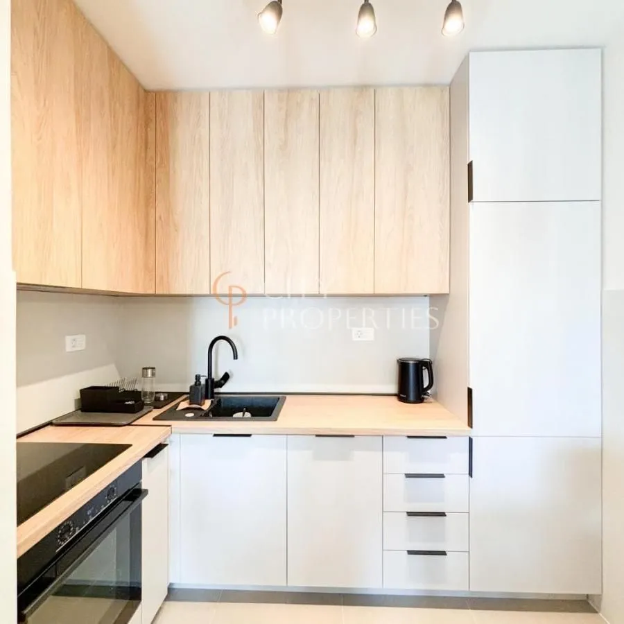 Modern kitchen with wooden cabinetry and built-in appliances.