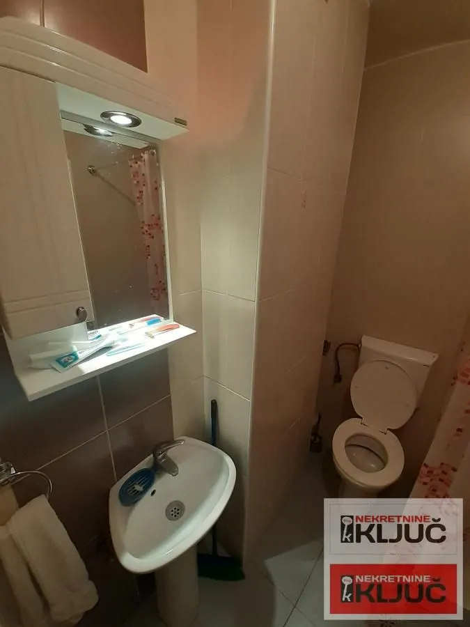 Manje kupatilo sa umivaonikom, ogledalom i wc šoljom.