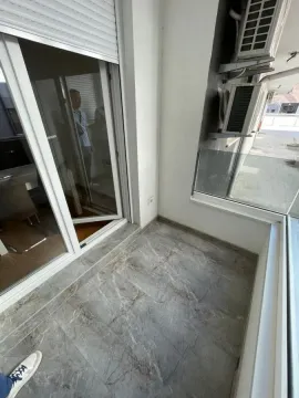Manji natkriveni balkon sa popločanim podom i spoljnim jedinicama klima uređaja. - image 6