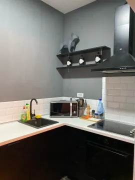 Manja moderna kuhinja sa crnim elementima i bijelom radnom pločom. - image 6