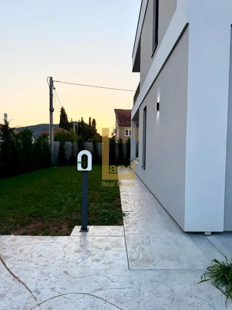 Pogled na dvorište i spoljašnjost moderne kuće sa stazom.