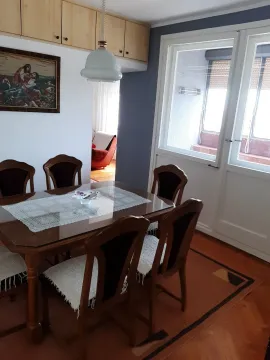 Dining area with a wooden table and chairs near a window. - image 7